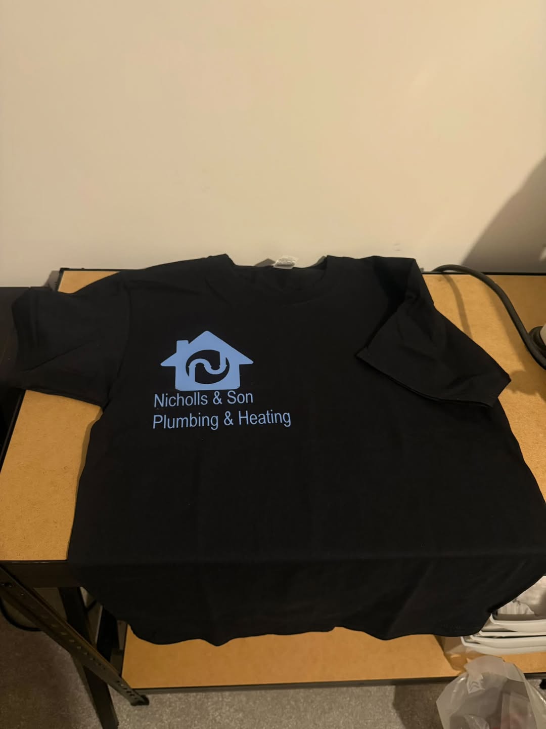 Black t-shirt printed with the Nicholls & Son Plumbing & Heating logo